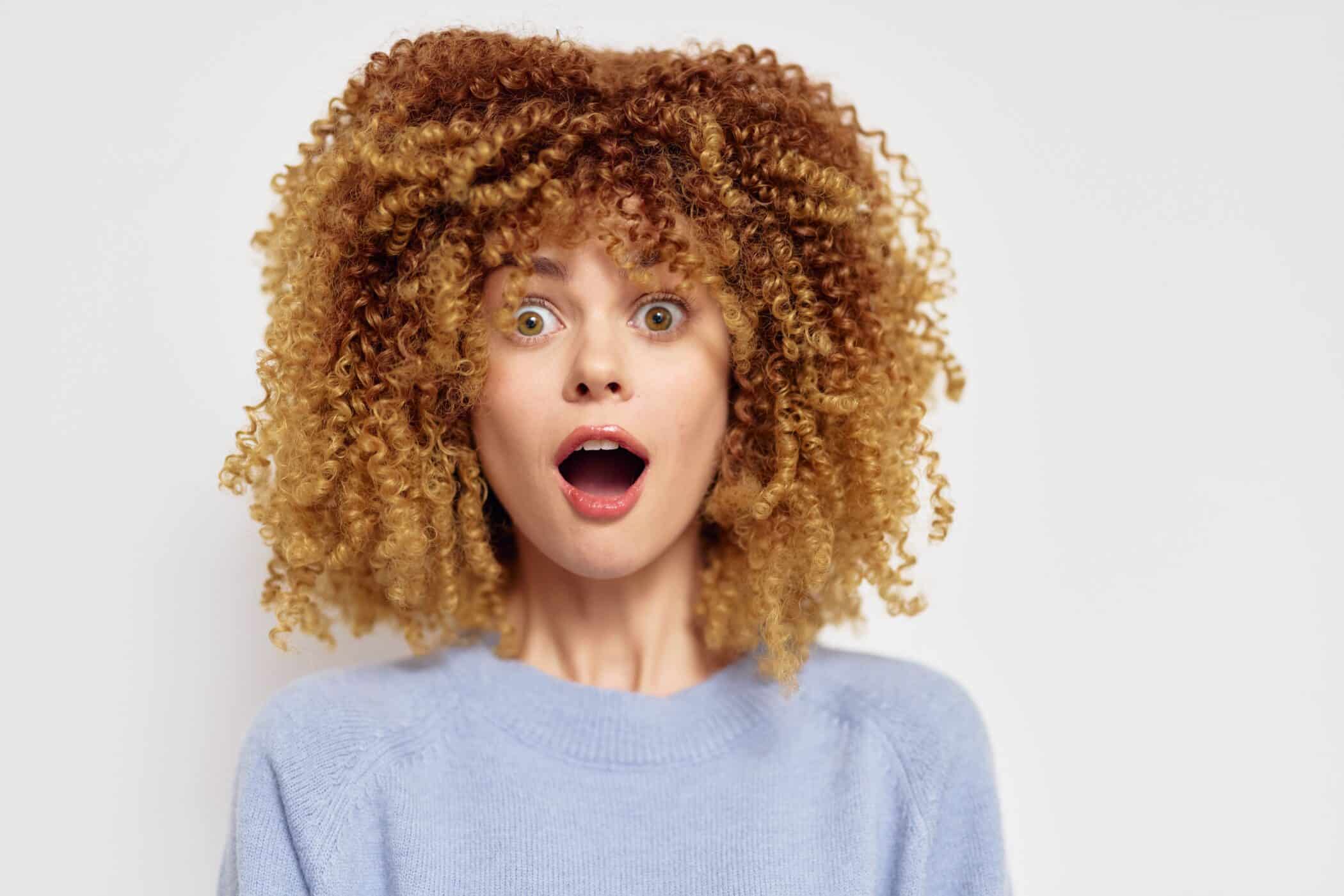 A woman shows off her tightly curled hair
