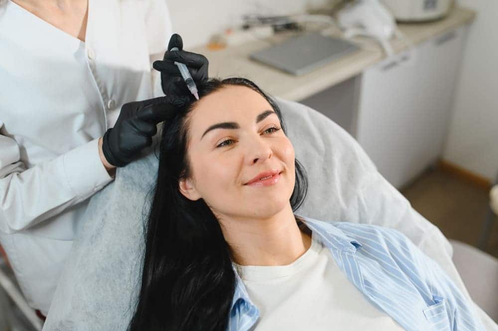 Woman in scalp treatment, wondering if she can work out after a hair transplant
