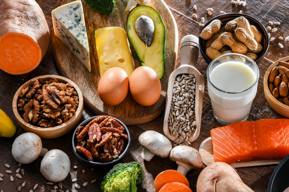 A spread of biotin-rich foods including eggs, salmon, nuts, and sweet potatoes that support healthy hair