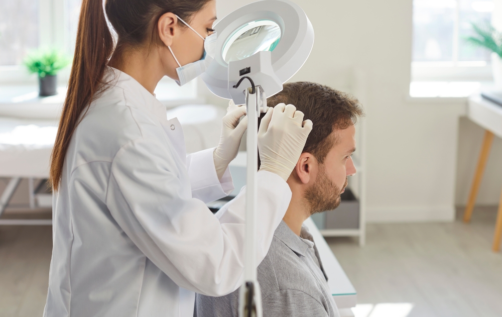 A doctor examines a patient’s hair. Dutasteride or finasteride may be chosen depending on the case.