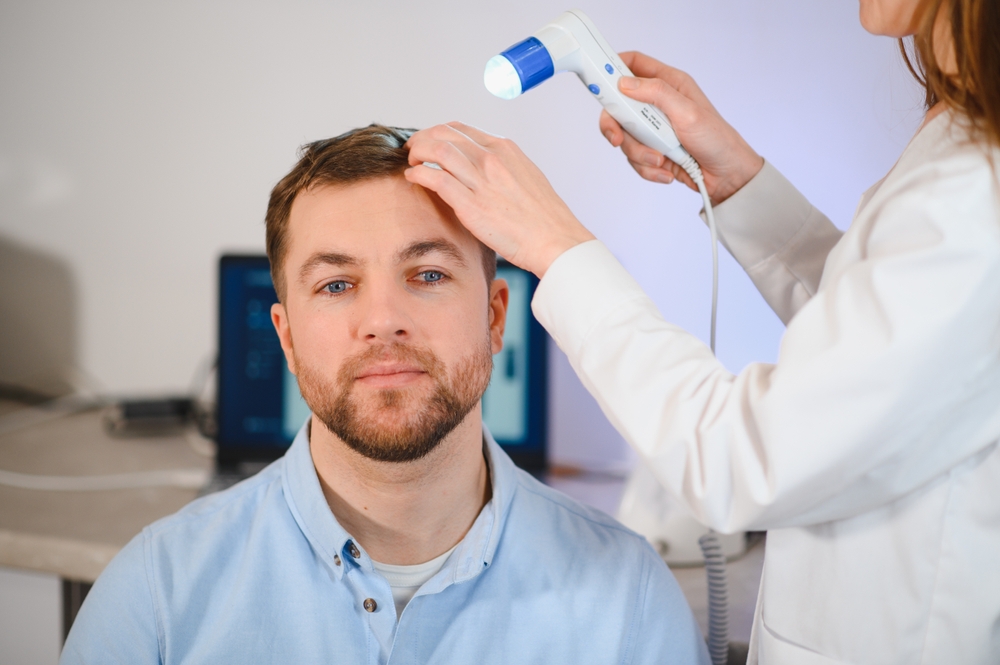 Hair loss specialist checking a patient's scalp to identify his Norwood scale stage